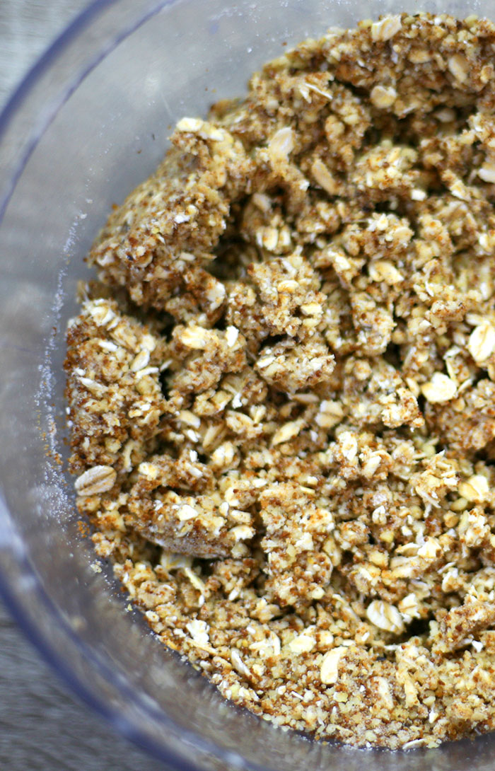 Food processor from above showing a brown crunchy crumble mixture.