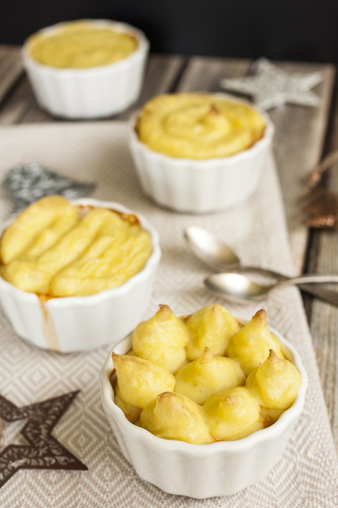 3 small white oven-safe pots with mashed potatoes. You cannot see the stew inside. 