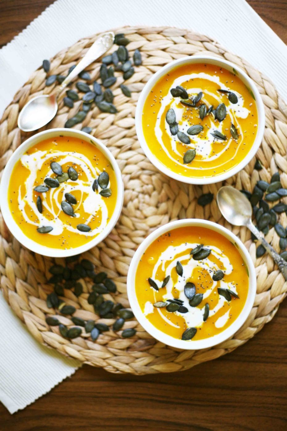 Simple Pumpkin Cream Soup from fresh Hokkaido pumpkin - 3 small bowl of pumpkin soup sprinkled with pumpkin seeds, chia seeds and dairy-free cream poured on top.