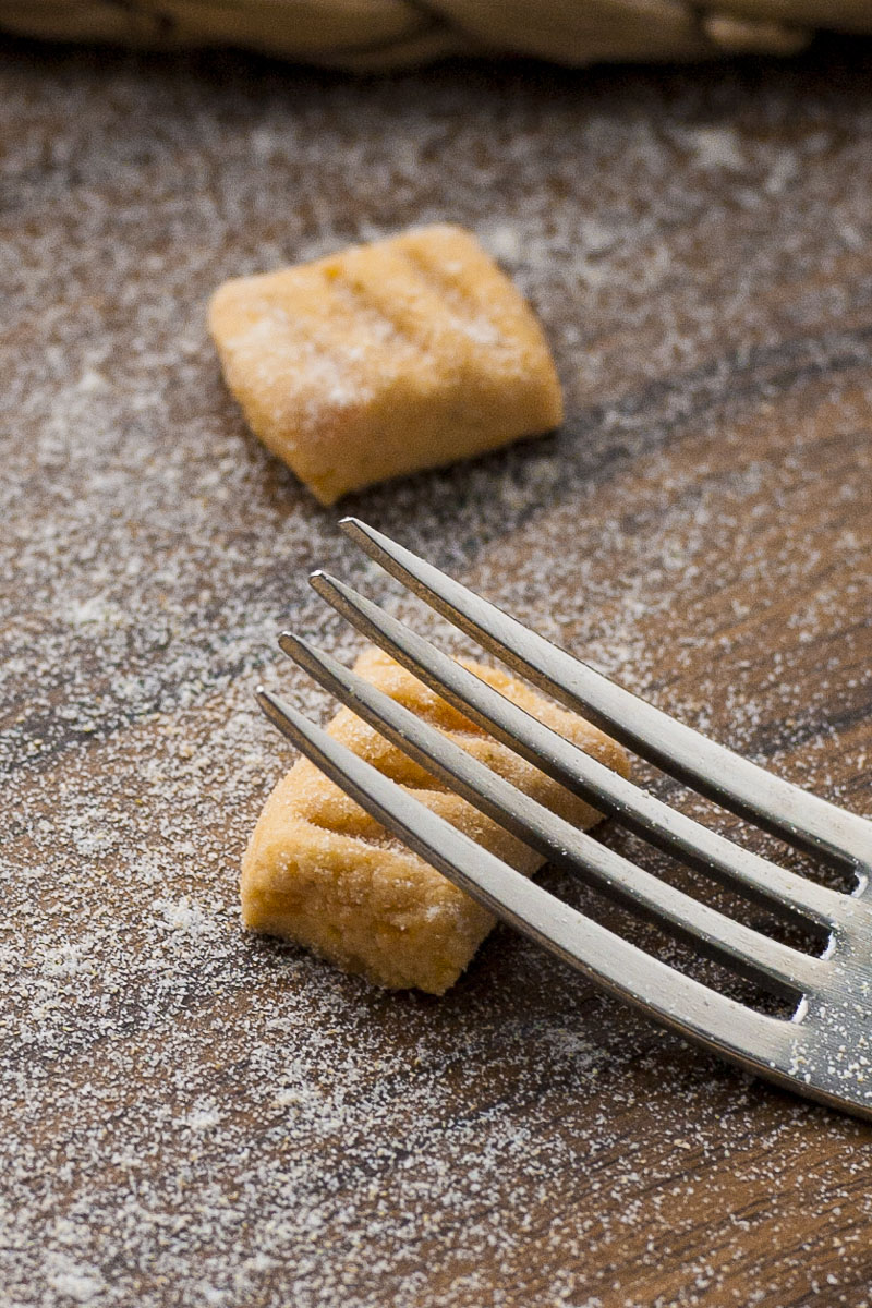 Soft orange rectangle-shaped pasta with a fork making a dent in it. 