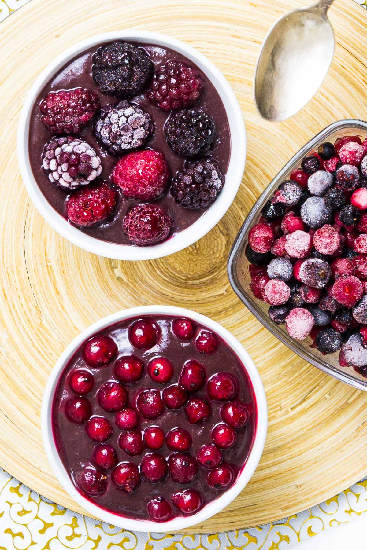 3 small bowls, one with vegan chocolate pudding topped with mixed berries, the other topped with red currant and one bowl is only fruits.