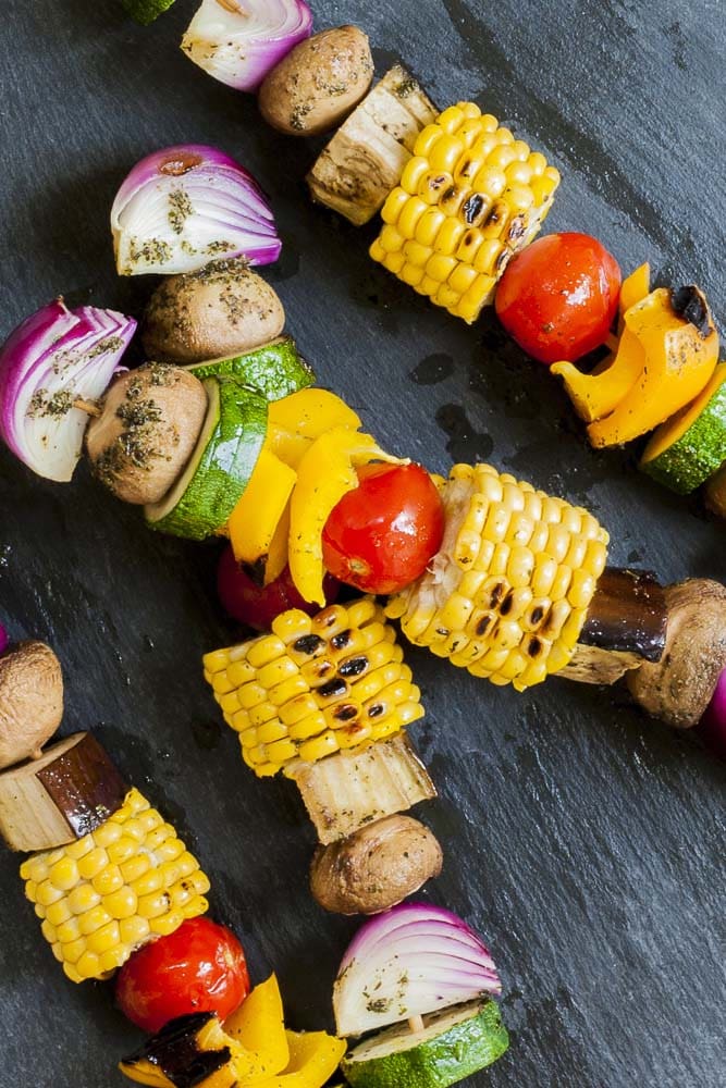 Close-up of grilled veggie kabobs on a grey plate