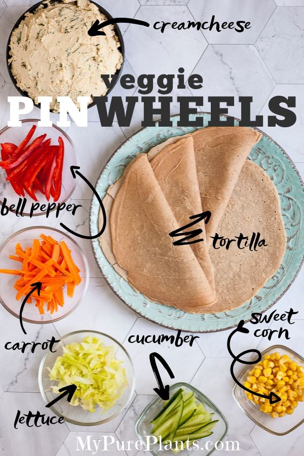 2 tortillas on a light blue plate and small glass bowls with colorful veggies like orange carrots, red bell pepper, green cucumber, yellow corn