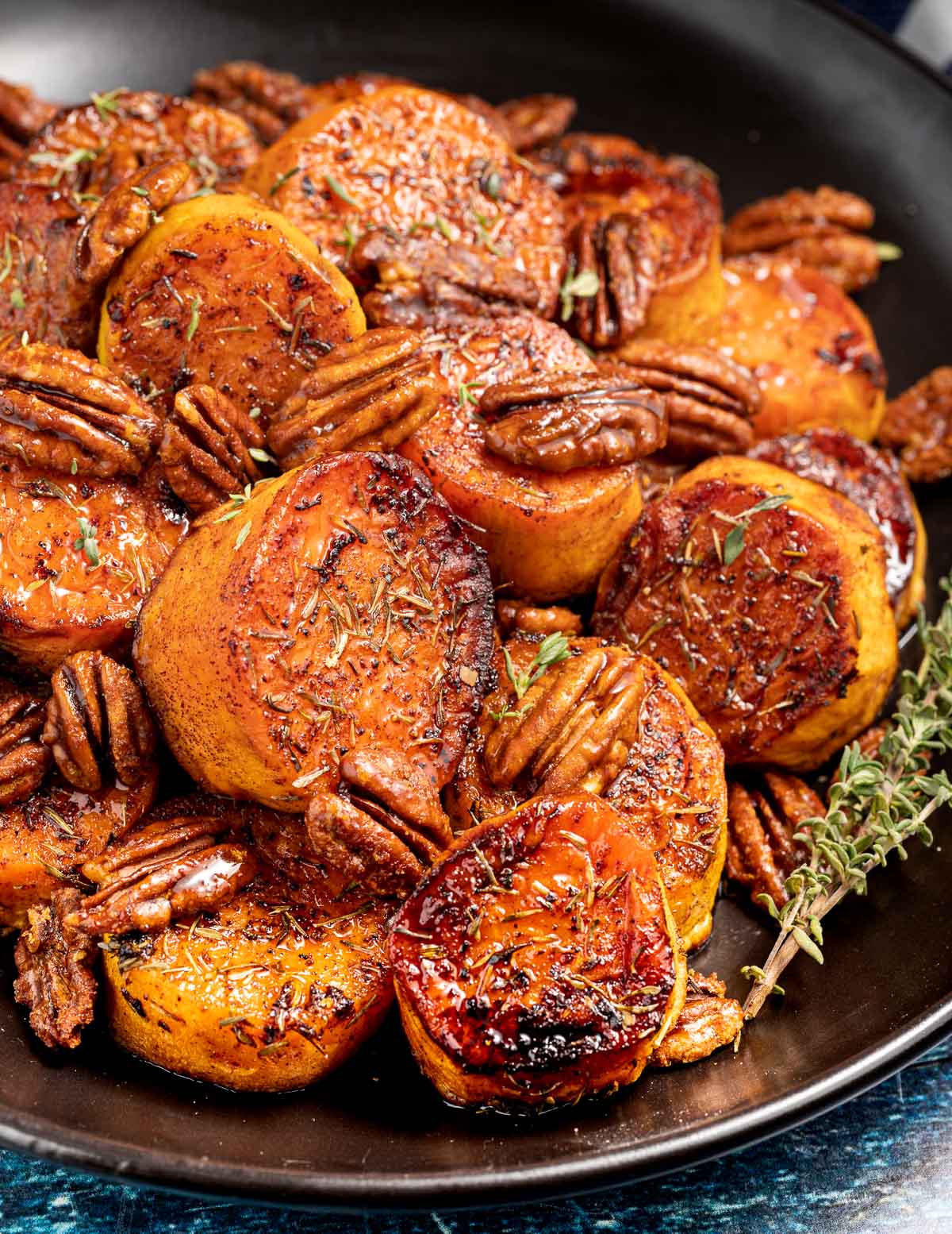 Swett potato disked charred on the edges with pecans sprinkled with rosemary 