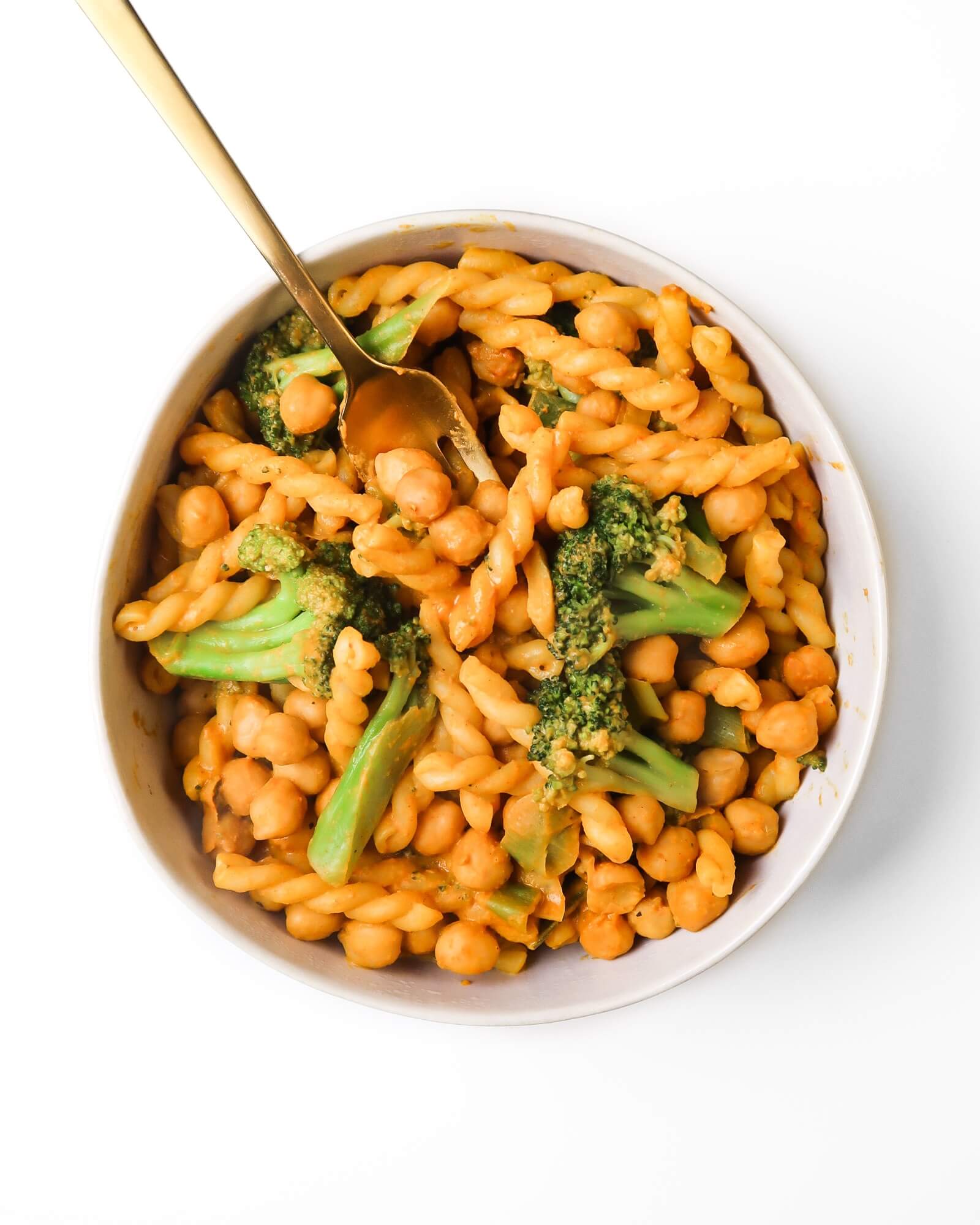Gemelli noodles in an orange-brown sauce with broccoli florets and chickpeas.
