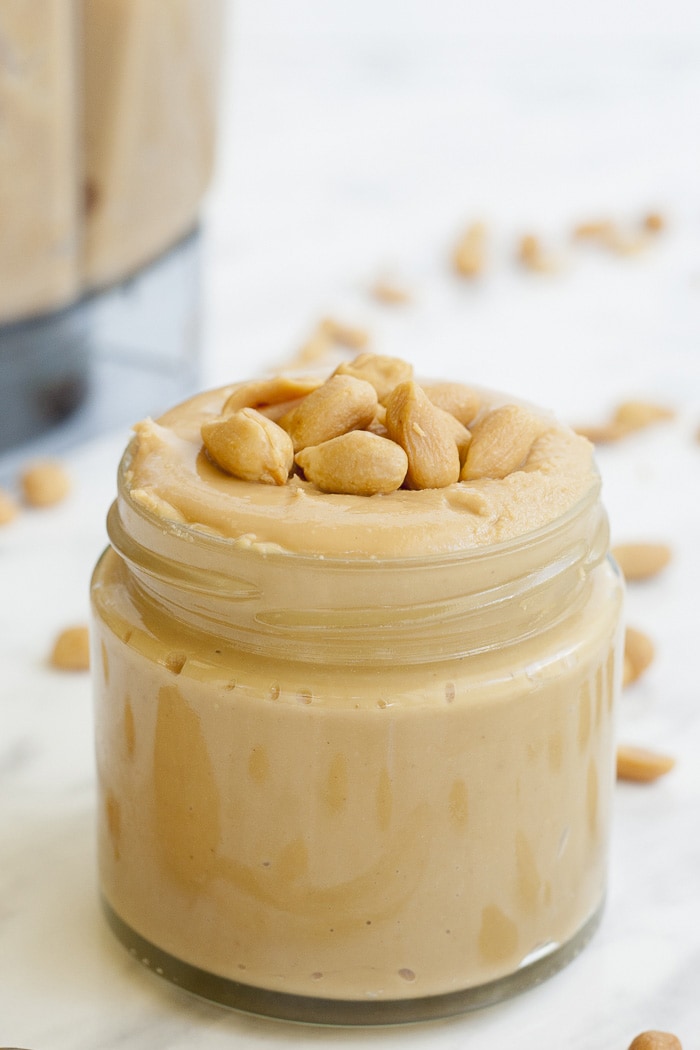 Close-up of a jar of peanut butter topped with peanuts