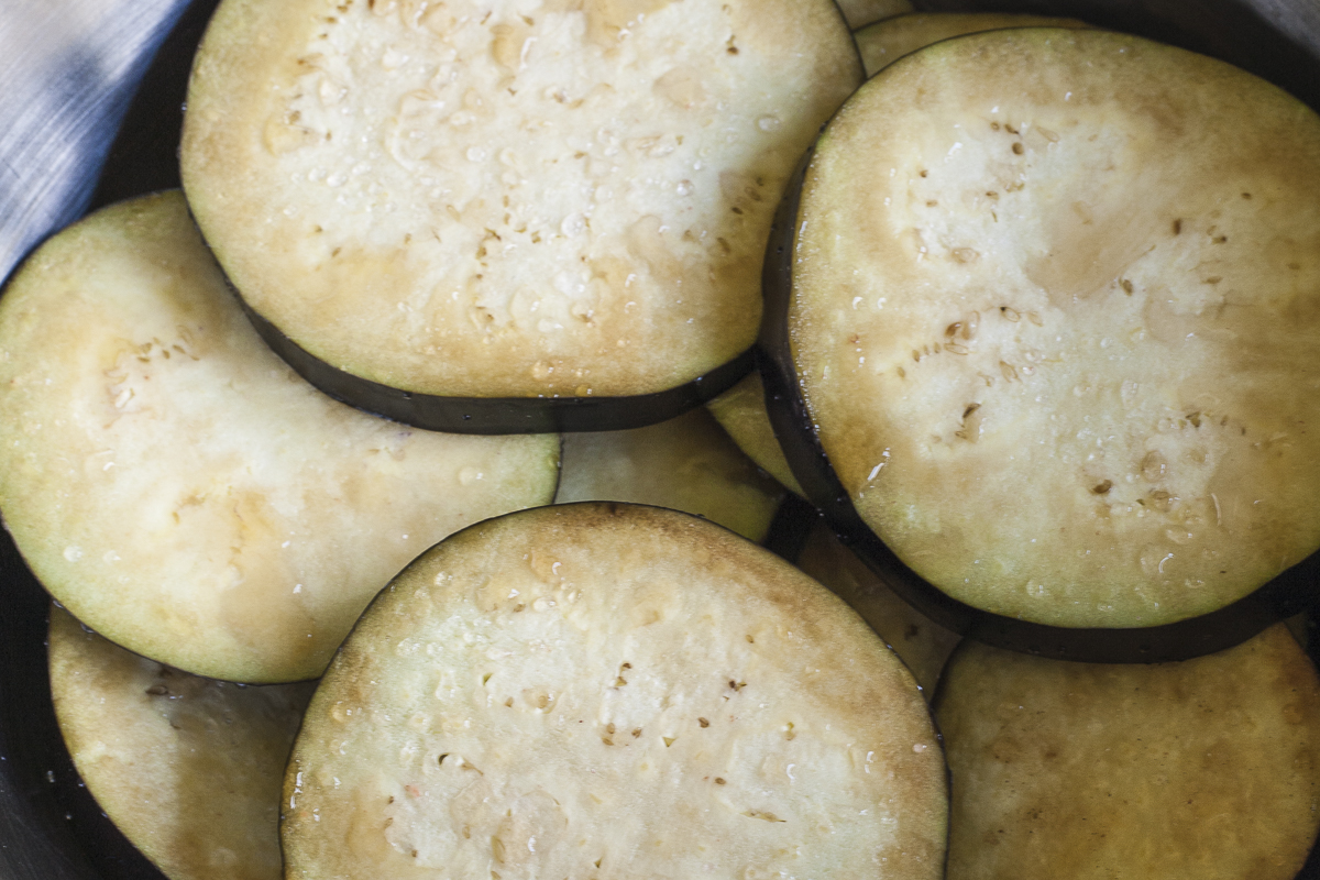 Yellow-brownish eggplant discs with water droplets