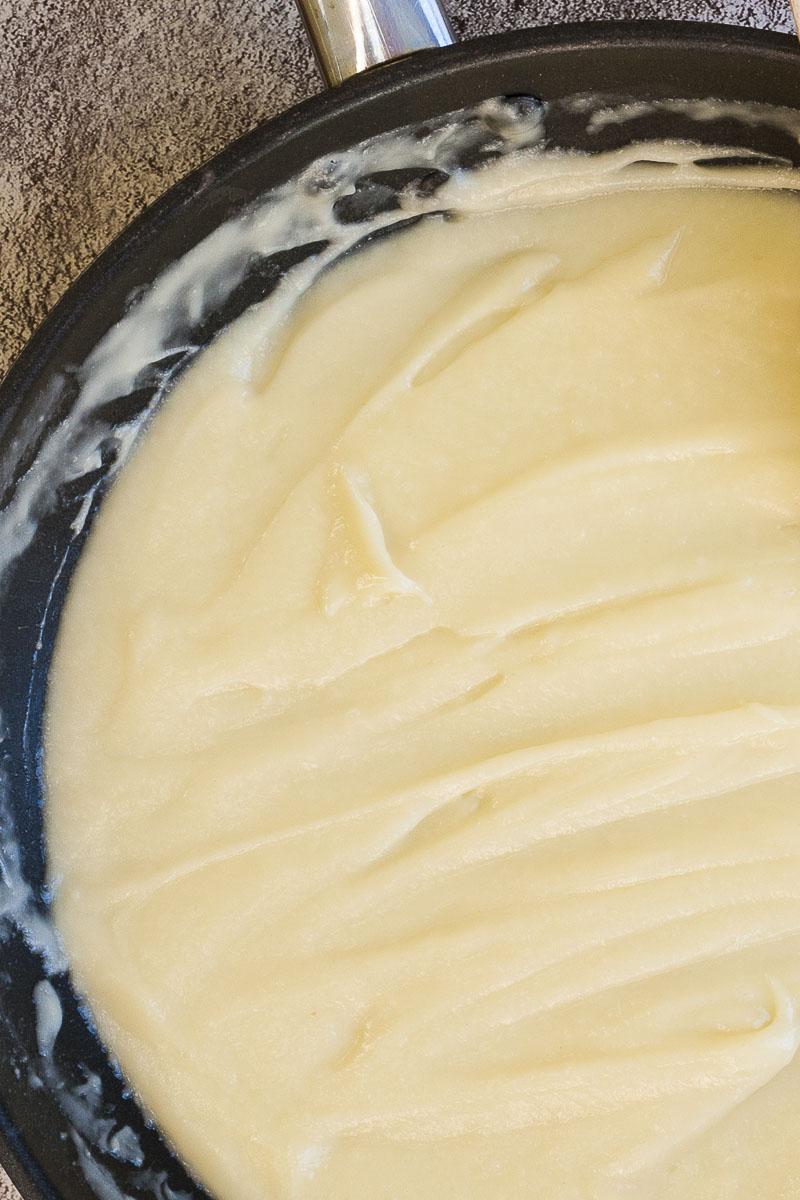 White sauce in black frying pan up close