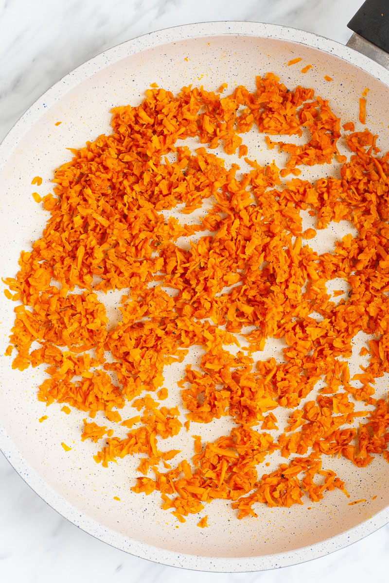 A white frying pan with crispy riced sweet potato.