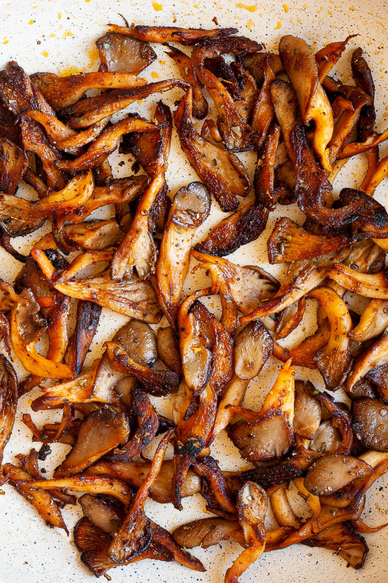 Crispy brown oyster mushroom shreds in a frying pan from above.