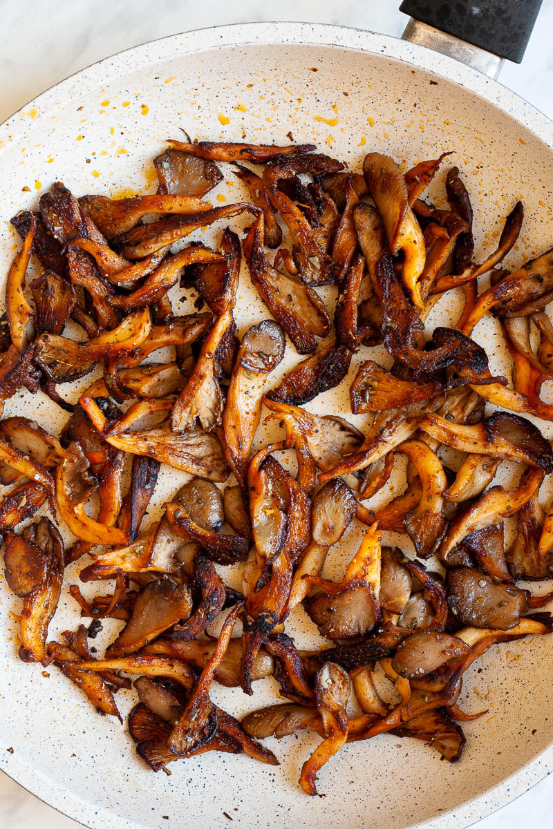 A frying pan from above with brown crispy mushroom shreds.
