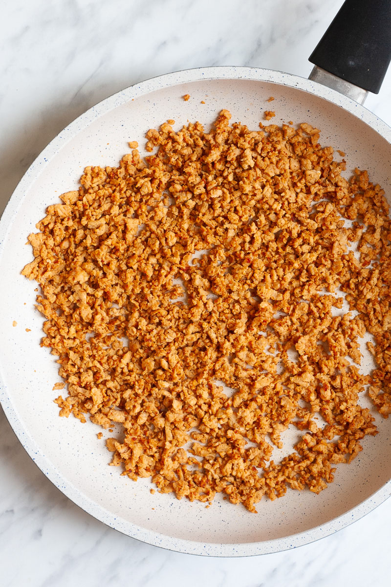 White frying pan with dark brown crumbles that reminds you of ground beef