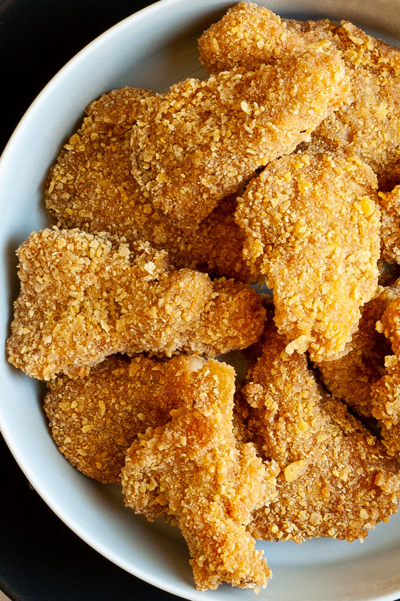 Brown breaded nuggets in a round plate.