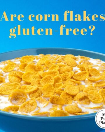 Blue bowl of milk with corn flakes with a text overlay saying are corn flakes gluten-free