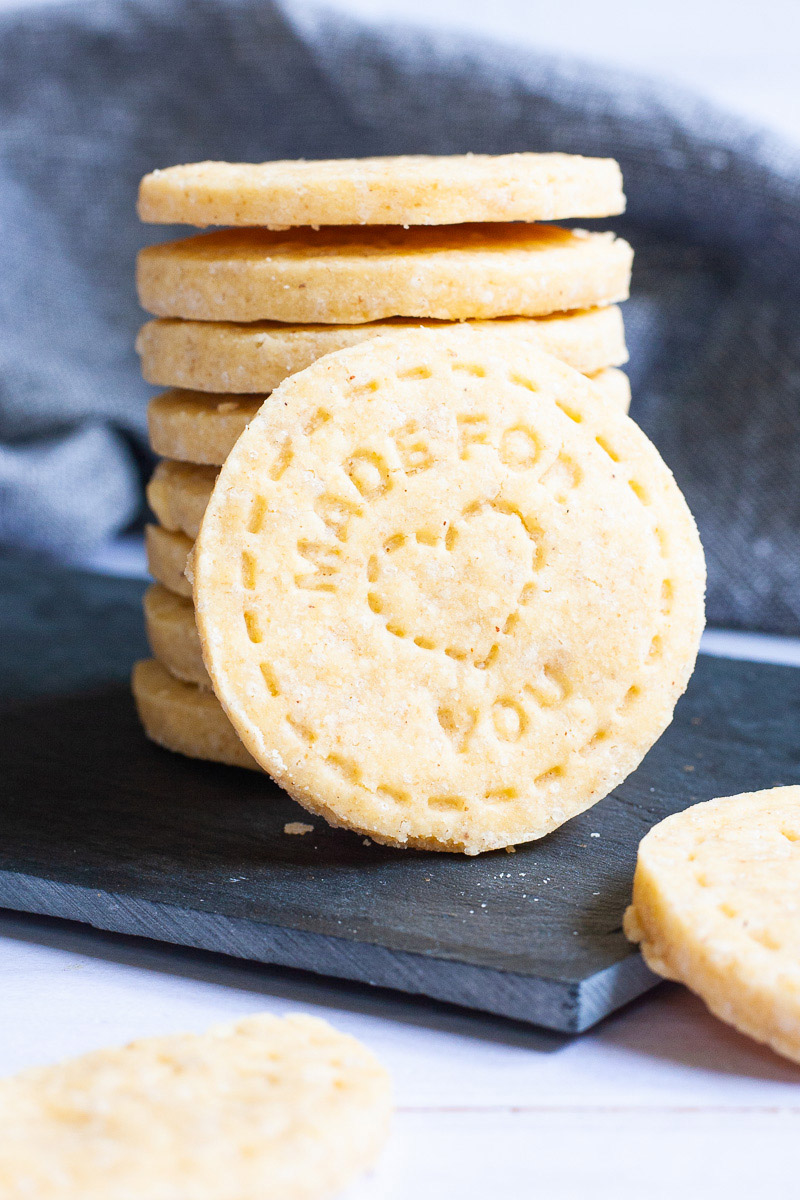 A stack of thin round cookies on a black board.