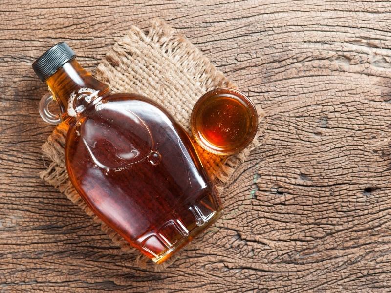 Dark brown syrup in a typical maple syrup glass.