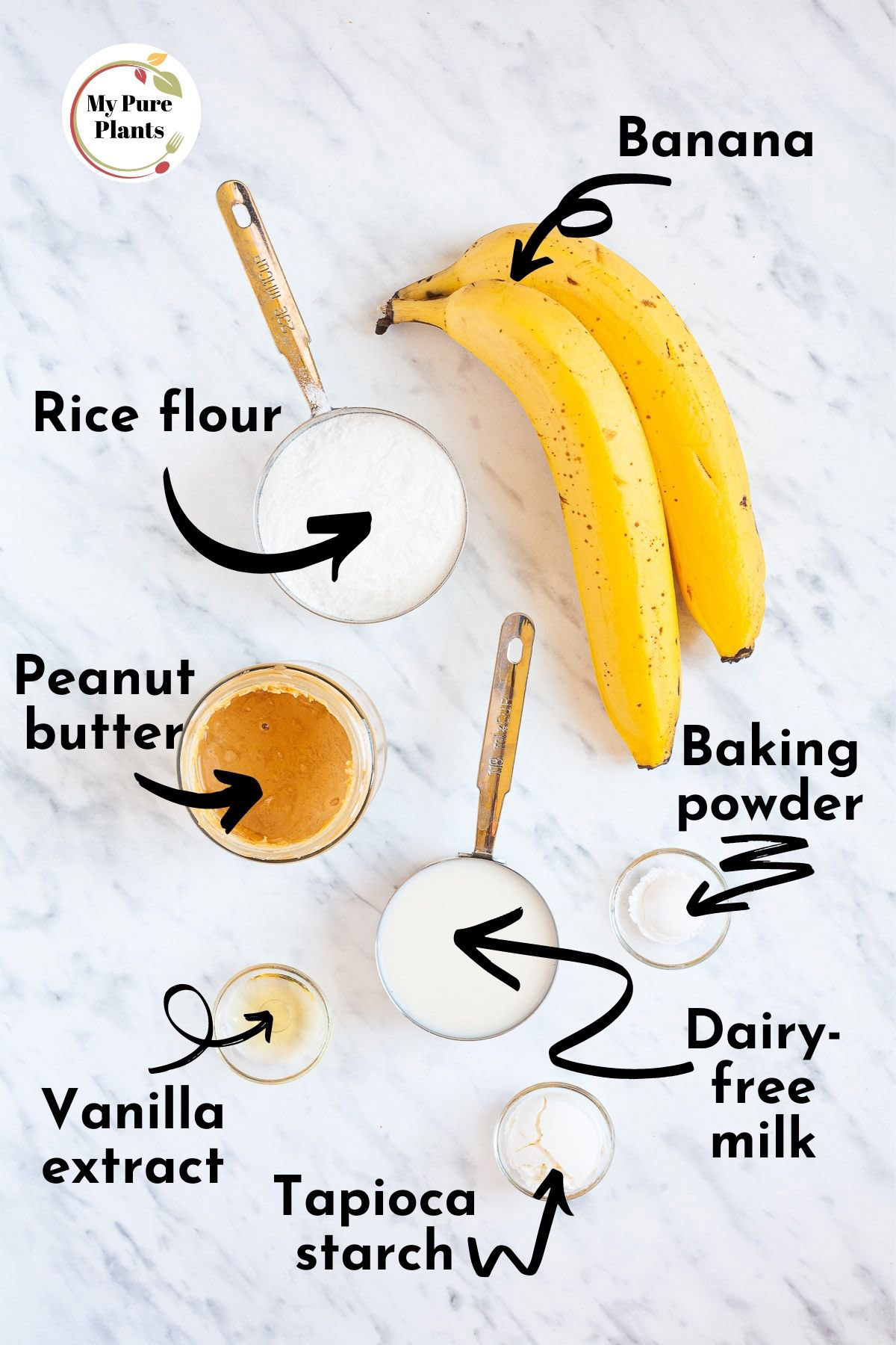 Ingredients of vegan banana waffles from above measured in small containers rice flour, peanut butter, tapioca starch, vanilla extract, baking powder and 2 yellow bananas