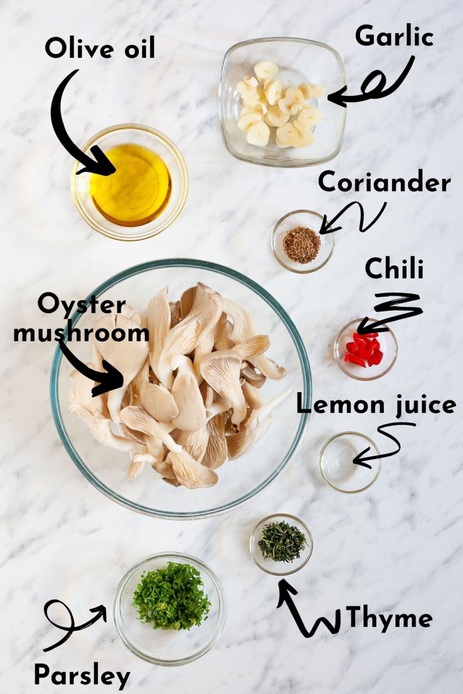 Ingredients to make pan-fried oyster mushrooms is measured in glass bowls like light brown oyster mushroom, olive oil, garlic slices, coriander, chili, lemon juice, thyme and parsley all with text overlay