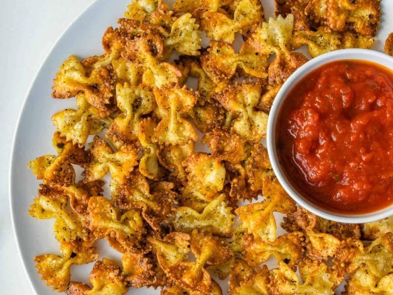 White plate full of crispy baked farfalle pasta 