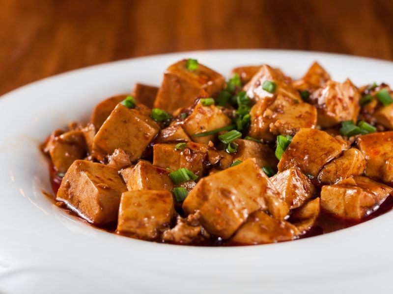 Brown juice tofu cubes served in a white bowl