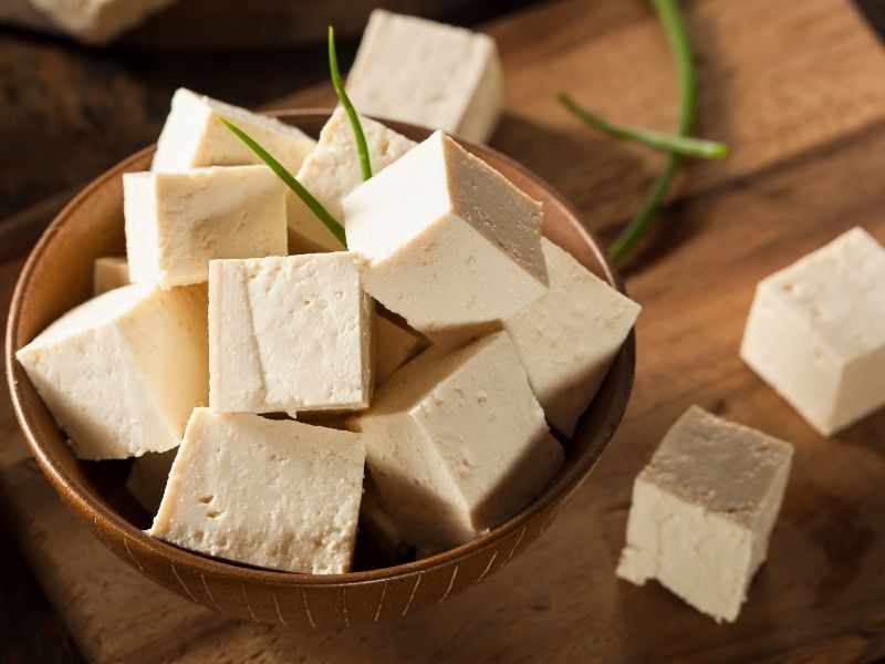 White tofu cubes in a brown wooden bowl