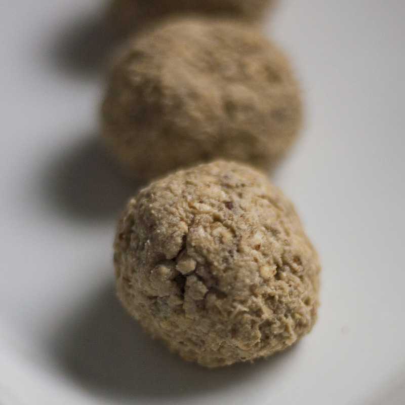 Brown raw balls on a white plate