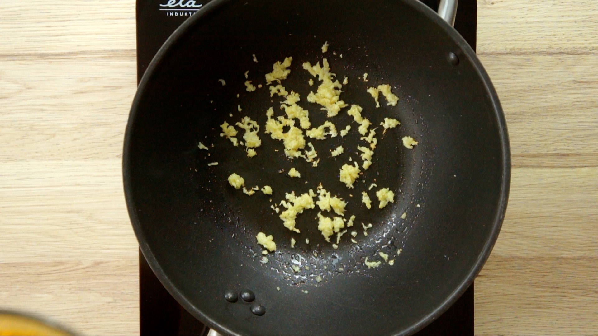 Grated ginger and garlic in a wok. 