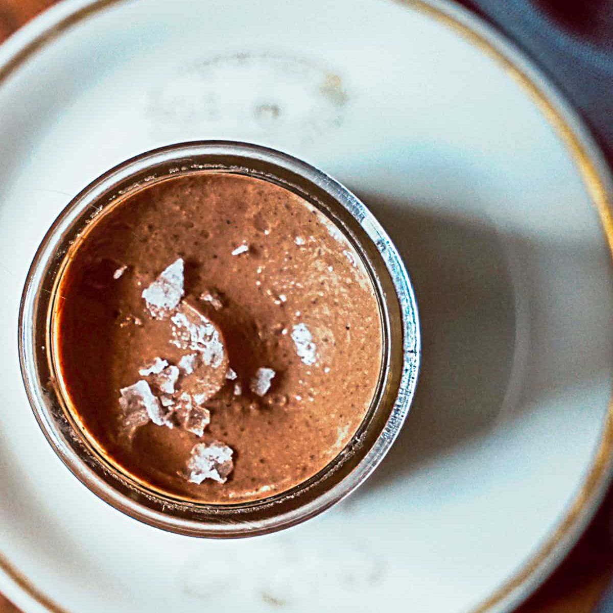A dark brown chocolate mousse in a small glass container. 