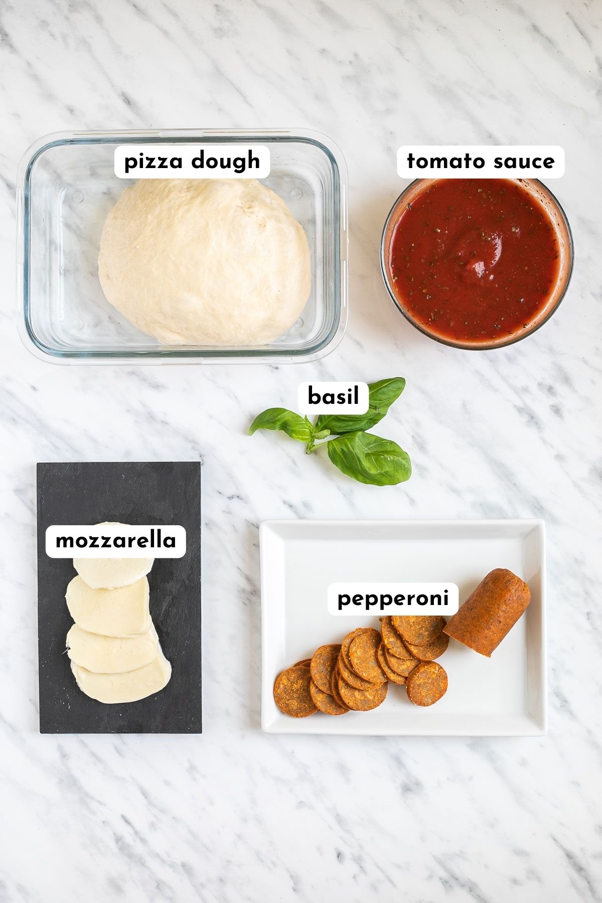 Ingredients of vegan pepperoni pizza in small containers like pizza dough, tomato pizza sauce, sliced mozzarella, basil leaves and pepperoni slices. 