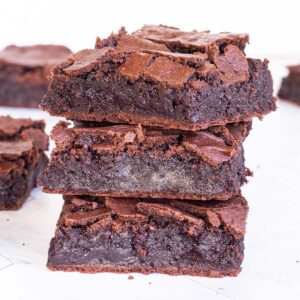 3 square brownies on top of each other with fudgy middle and crackly top.