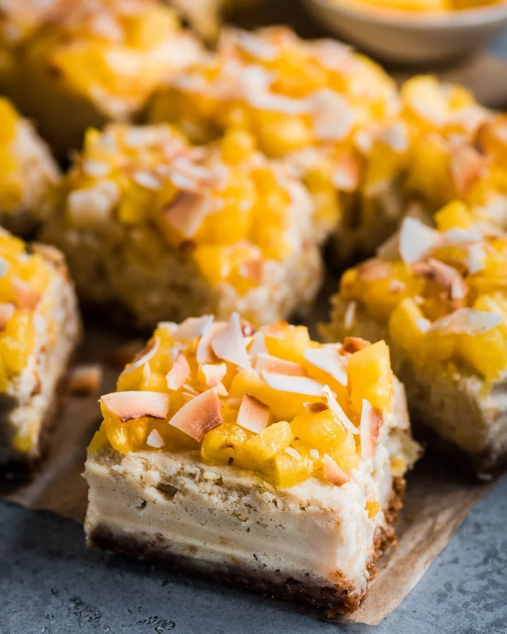 Mango cheesecake bars on a cutting board.