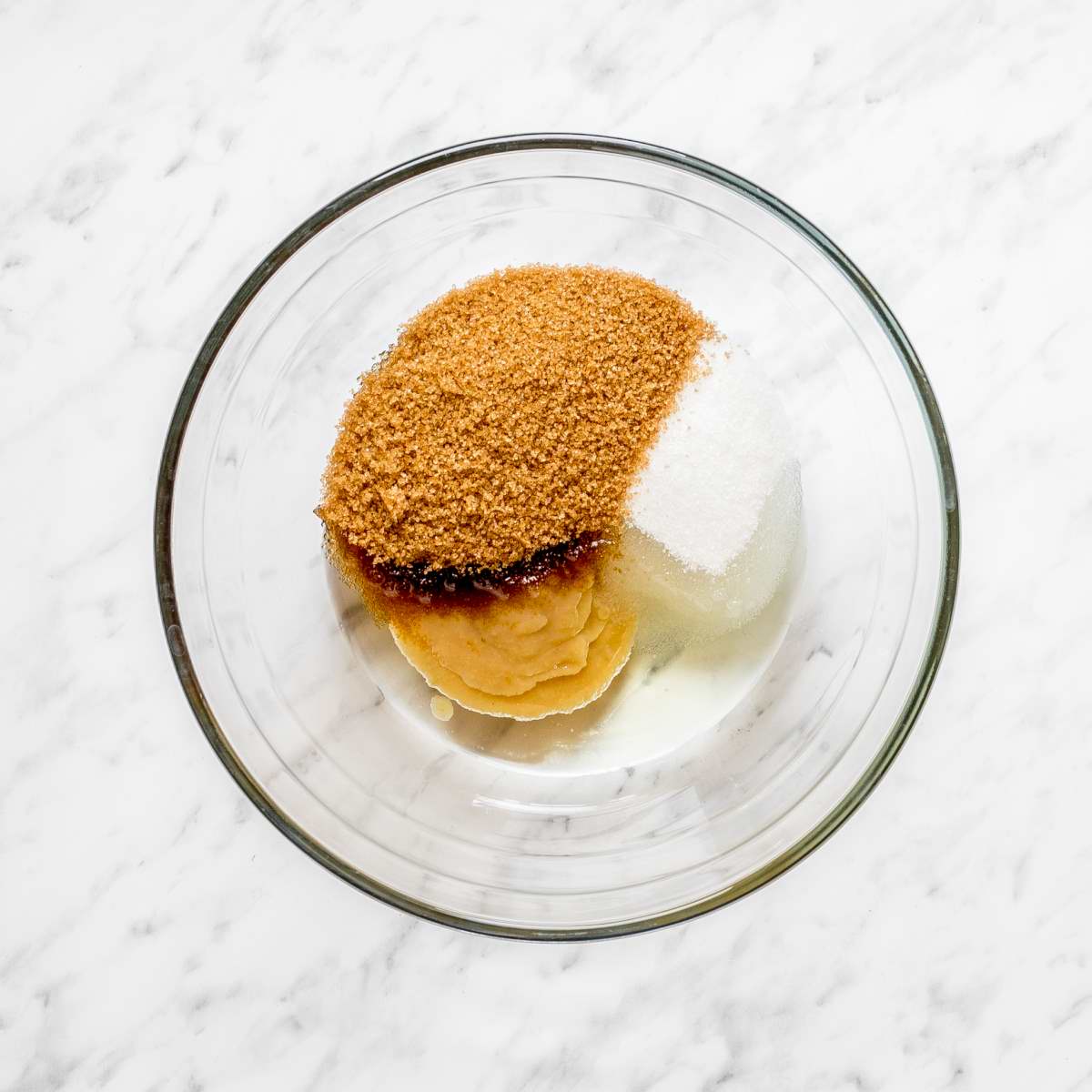 Glass bowl with brown sugar, white sugar, apple sauce, and oil