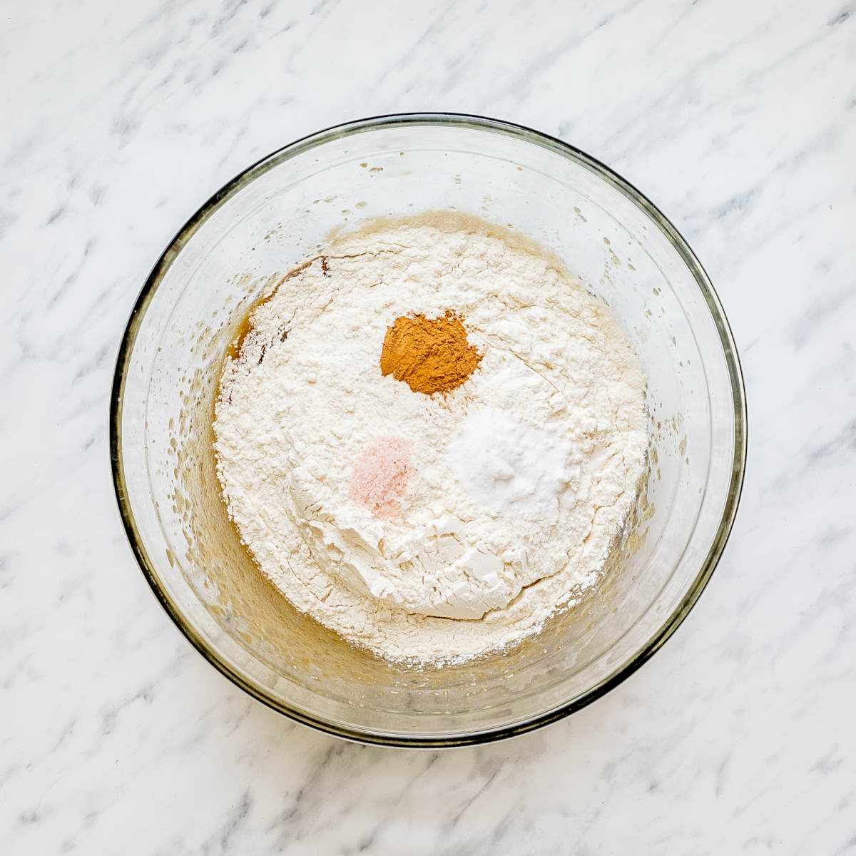 Glass bowl with flour, cinnamon, salt, and soda.