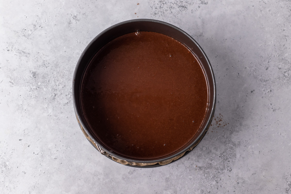 Cake pan with dark brown cake batter.