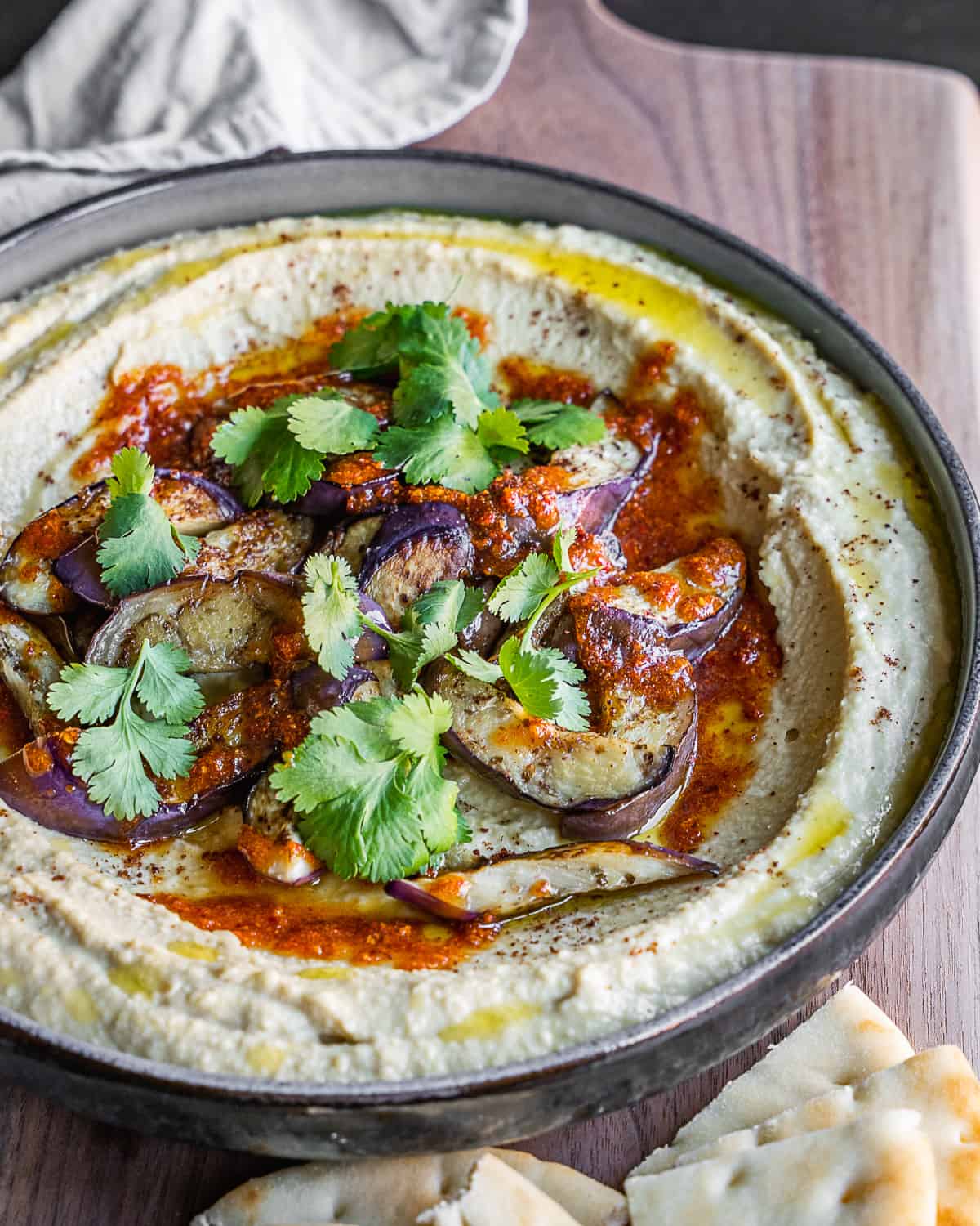 Caramelized eggplant hummus in a bowl with toppings. 
