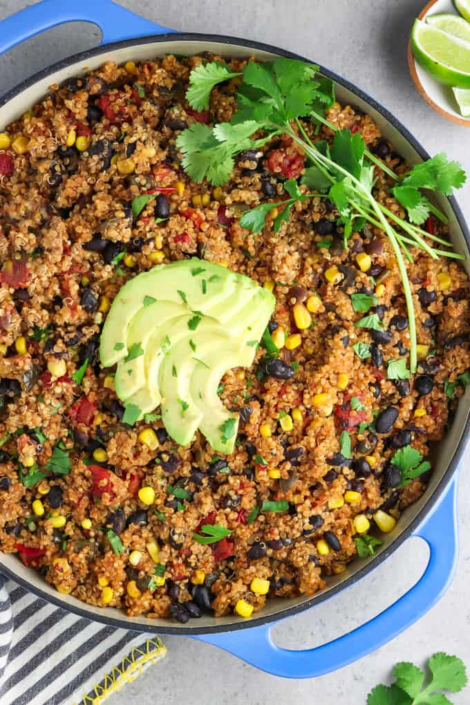 Overhead view of one pan Mexican quinoa topped with avocado slices and cilantro. / This One Pan Mexican Quinoa is a hearty flavor-packed meal and it's a breeze to make. It's a total weeknight winner that'll take about 30 minutes on the stove, and you'll only have to clean one pan!