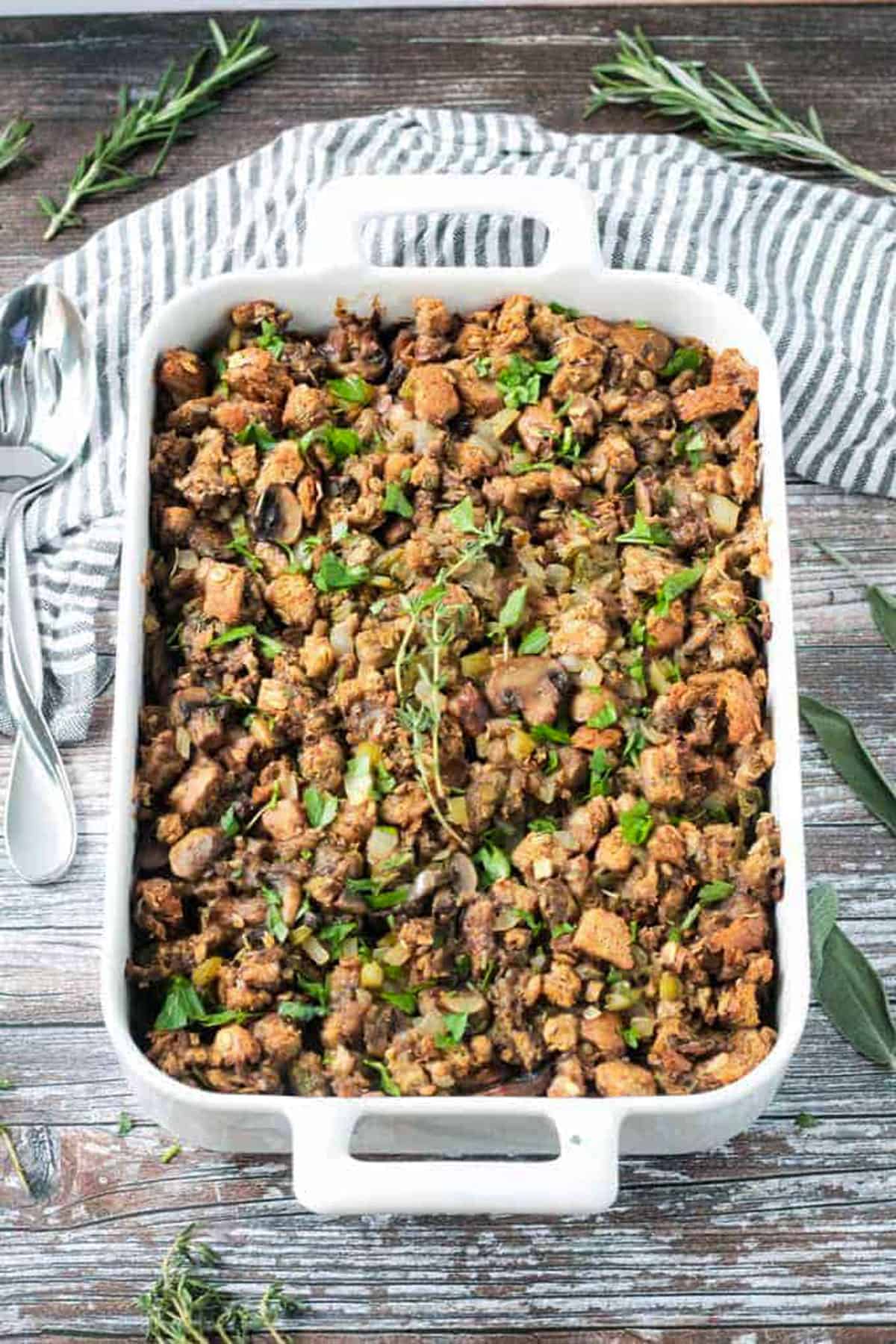 Finished dish of vegan stuffing with mushrooms in a white baking dish.
